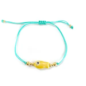 Bracelet tissé vert menthe avec breloque poisson jaune et cordon réglable pour femme.