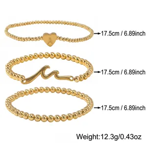Ensemble de trois bracelets élastiques en perles dorées avec pendentifs cœur et vague