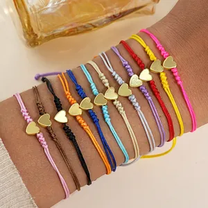 Colorful braided string bracelets with gold heart charms for stackable everyday wear