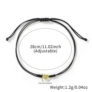Minimalist black woven bracelet with tiny gold heart charm and adjustable cord closure