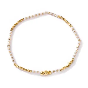 Minimalist Bohemian bracelet with gold copper beads and white striped rice beads.
