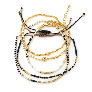Set of handmade seed bead bracelets with gold beads in black and white contrast design