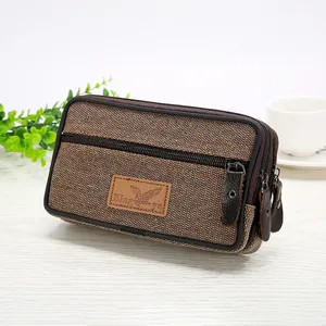 Macro view of men's brown canvas phone pouch showing three-layered zipper design and texture