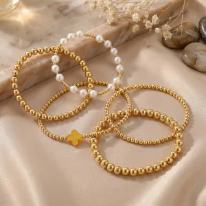 Elegant gold beaded bracelet set featuring pearls and a clover charm for women