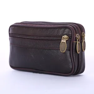 Detailed close-up of a brown leather waist bag with triple zipper compartments.