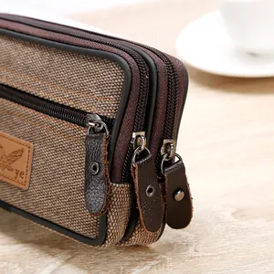 Close-up of brown canvas waist bag with three durable zippers and leather pulls
