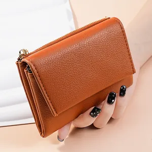 Close-up of brown leather mini wallet with lychee grain texture and side accordion design