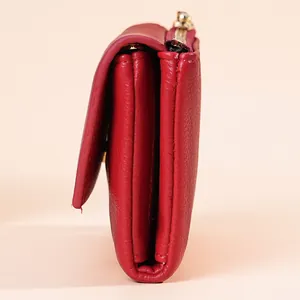 Side profile close-up of a red leather mini wallet showing the multi-layered structure