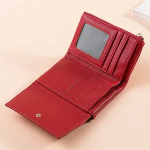 Detailed close-up view of a red pebbled leather bifold wallet showing card slots and ID window