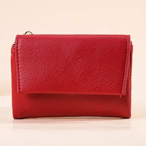 Front view of a minimalist red pebbled leather mini wallet with tri-fold design for women