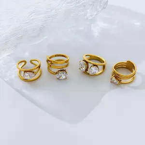 Detail view of four gold-plated multi-layer rings featuring teardrop and oval zircons.