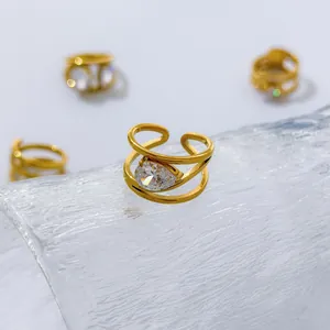 Detail of 18K gold plated titanium steel ring with teardrop zircon on glass.