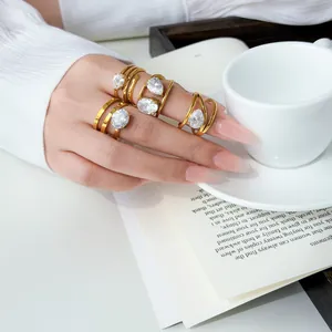Close-up detail of 18K gold plated multi-layer rings with water drop zircon on hand