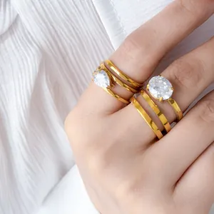 Detailed macro view of multi-layer gold rings featuring pear and oval cubic zirconia