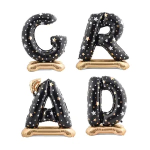 Standing black and gold foil balloon set forming GRAD with star patterns for graduation