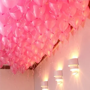 Large collection of pink heart balloons decorating a ceiling for romantic wedding party