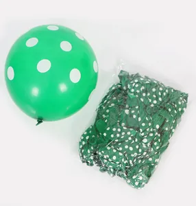 Detailed view of green polka dot latex balloon and its bulk pack in transparent bag
