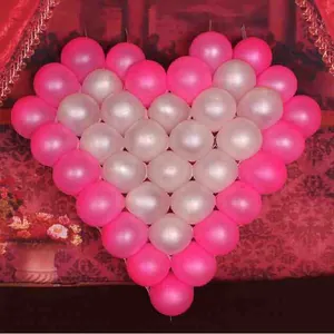 Close-up of pink and white latex balloons arranged in a large heart shape for weddings