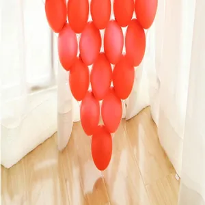 Close-up of small red latex balloons arranged in a decorative grid on a wooden floor.