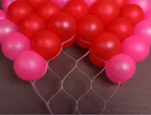 Detail showing pink and red latex balloons held by a transparent heart-shaped mesh grid
