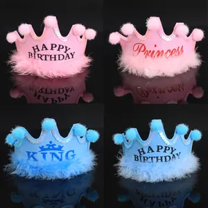 Detail view of pink and blue birthday crown hats with pom-poms and soft feathers