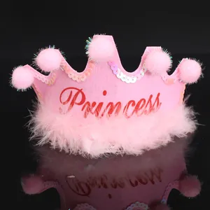 Detailed view of pink princess crown party hat with fluffy pompoms and sequins.