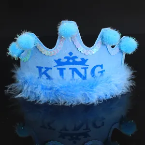 Close-up detail of light blue felt birthday crown with sequins and fuzzy pom-poms
