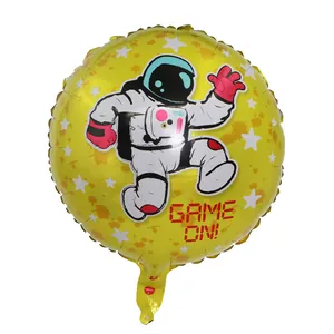 Macro view of a round yellow astronaut foil balloon with Game On pixel text for party