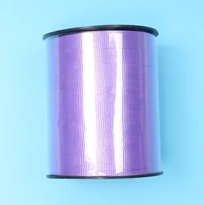 Close-up view of a large spool of purple satin ribbon for DIY wedding decorations