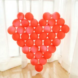 Grande forma a cuore fatta di palloncini in lattice rosso vibrante per le nozze.