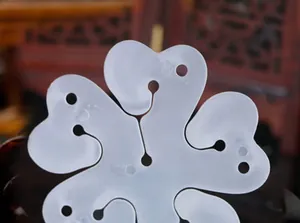 Primer plano de clip de globo 5 en 1 de plástico translúcido blanco con forma de flor de ciruelo