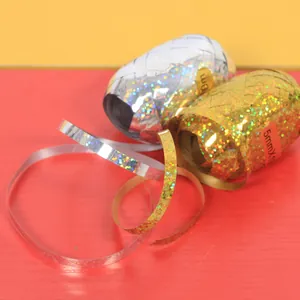 Macro view of glittering holographic gold and silver laser ribbons for festive balloon decoration