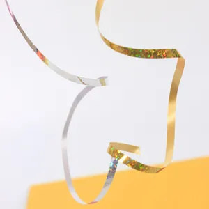 Macro view of curly laser gold and silver ribbons showing metallic glitter texture for party