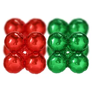 Close-up macro view of vibrant red and green four-leaf clover-shaped foil balloons for Christmas.