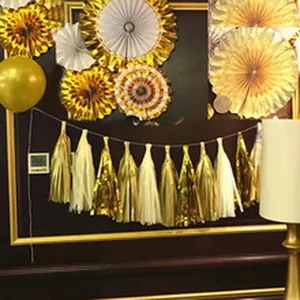 Close-up of golden and white 35cm paper tassels hanging for party decoration
