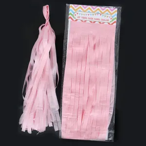 Detail view of pink DIY tissue paper tassel garland in packaging and fully assembled