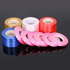 Detail view of various colorful satin ribbon rolls for balloon and party decor.