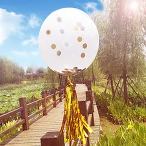 Detailed view of a clear confetti balloon with a gold foil tassel for party decor