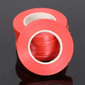 Close-up detail view of multiple stacked bright red balloon ribbons for festive party decoration