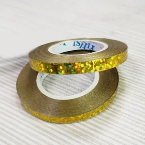 Macro view of gold holographic glitter ribbon rolls for party and wedding decor
