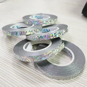 Close-up of holographic silver balloon ribbons with shimmering dot pattern for party decor.