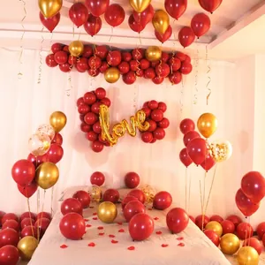 Detailoverzicht van romantische rode en gouden ballondecoratieset voor bruiloften