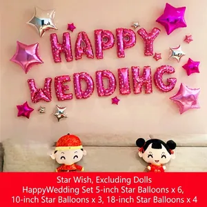 Detailweergave van roze folieballonnen 'HAPPY WEDDING' en stervormige feestversieringen.