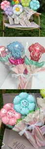Detail view of colorful flower-shaped balloons with 'LOVE' wrapping and lace bows.