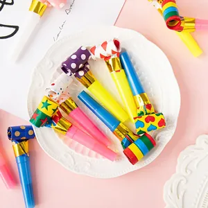 Colorful assorted paper party blowouts with various patterns on white plate backdrop.