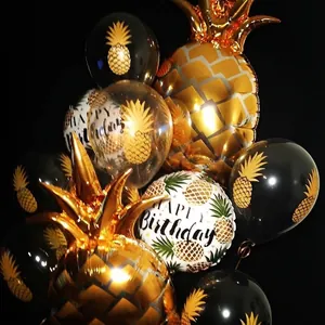Primer plano de globos de papel de piña dorada y globos de látex temáticos para fiestas