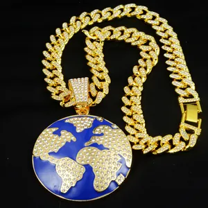 Close-up of iced out globe pendant with blue enamel and gold Cuban link chain.