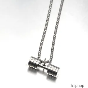 Close-up of a silver titanium steel dumbbell pendant on a box chain necklace.
