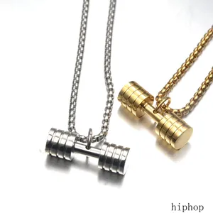 Detailed view of gold and silver barbell-shaped titanium steel pendant necklaces on a reflective surface
