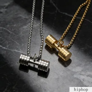 Close-up of gold and silver titanium steel dumbbell pendants on marble backdrop